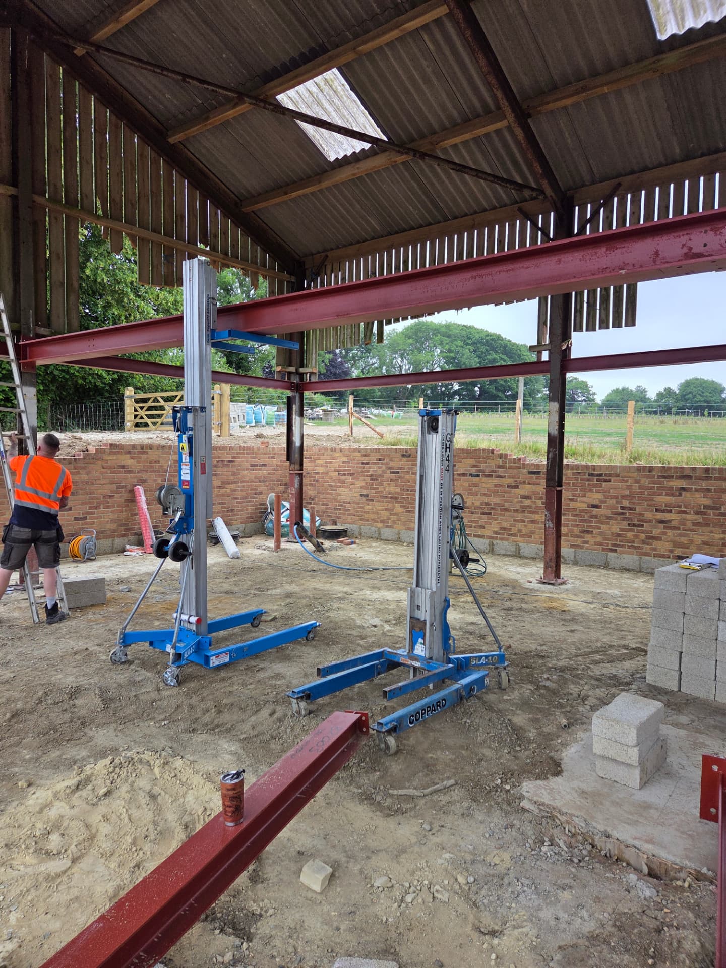 Red oxide steel portal frame installed inside a barn conversion